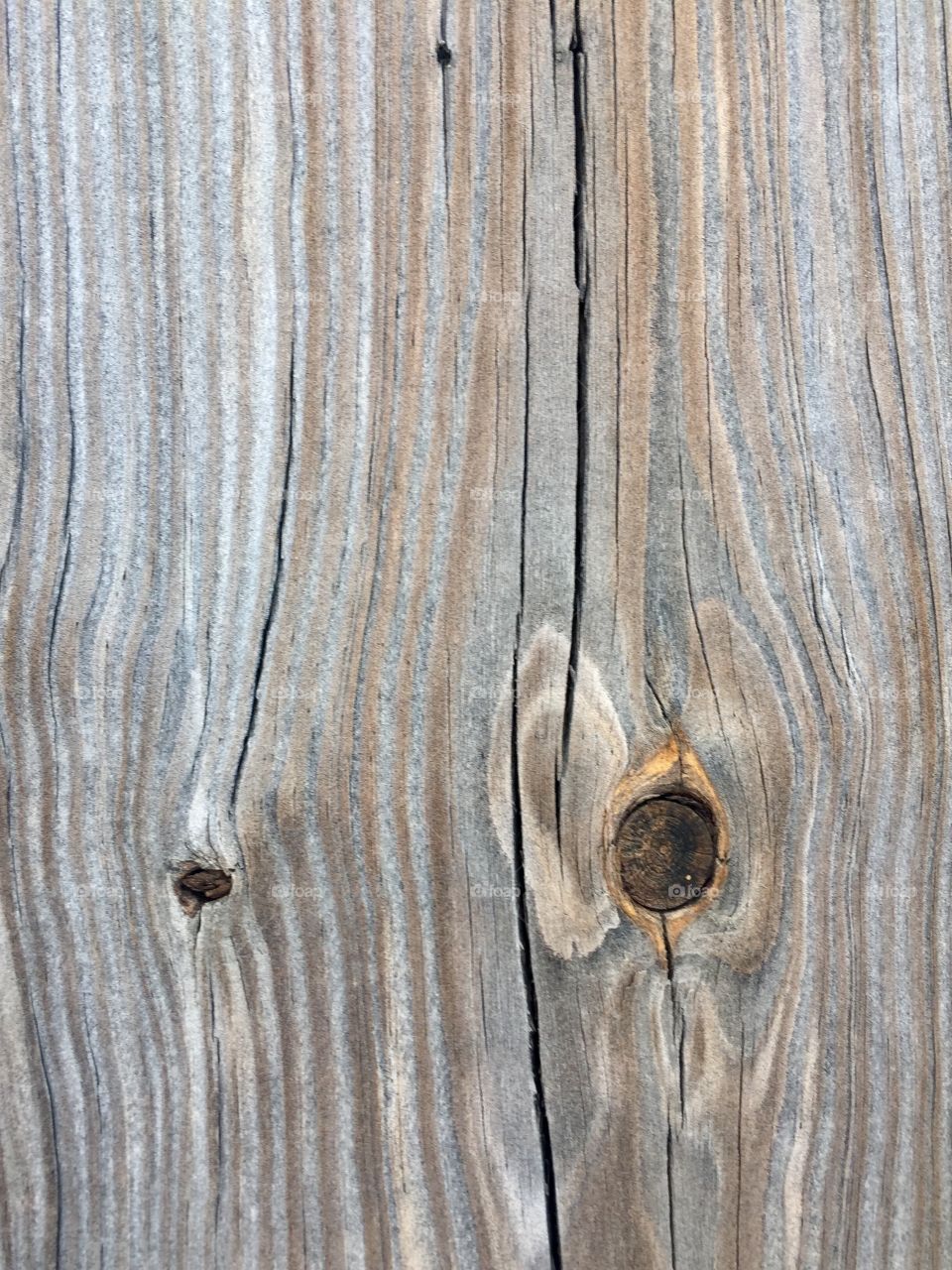 Weathered wood surface showing woodgrain texture detail with knots