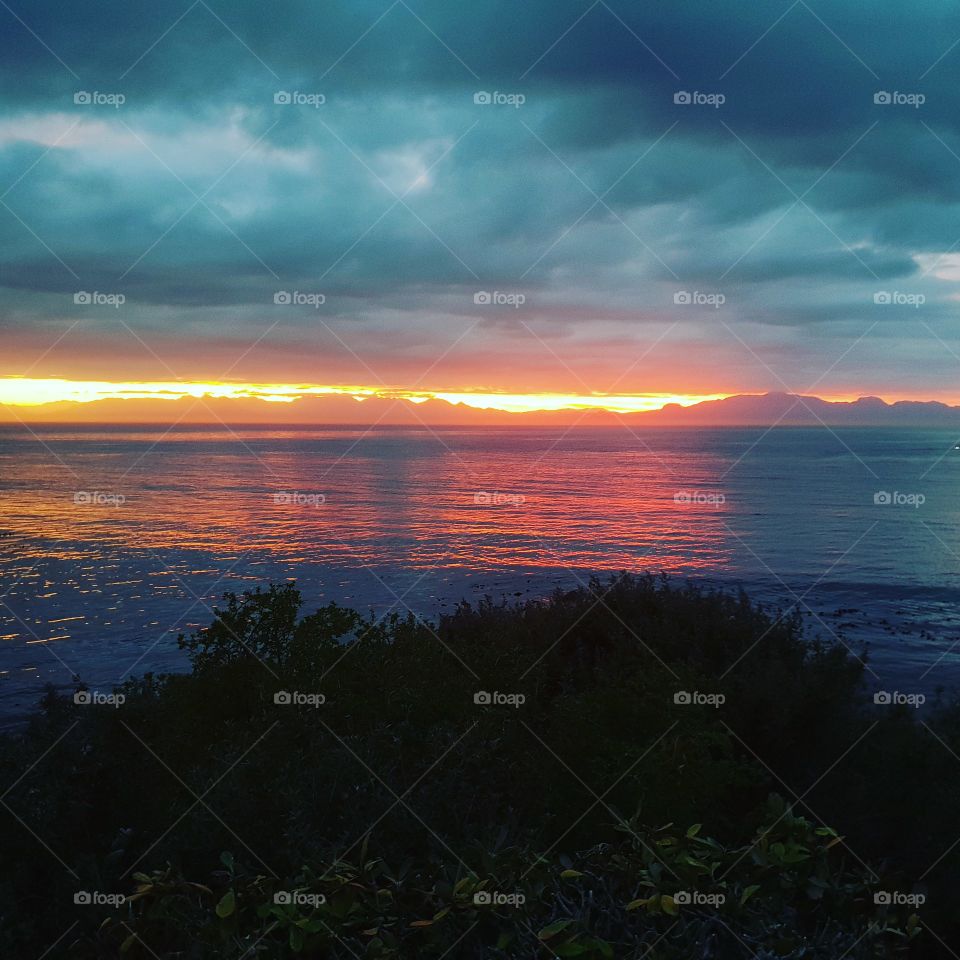 A fiery sunrise across the ocean.  Beautiful early morning peace.