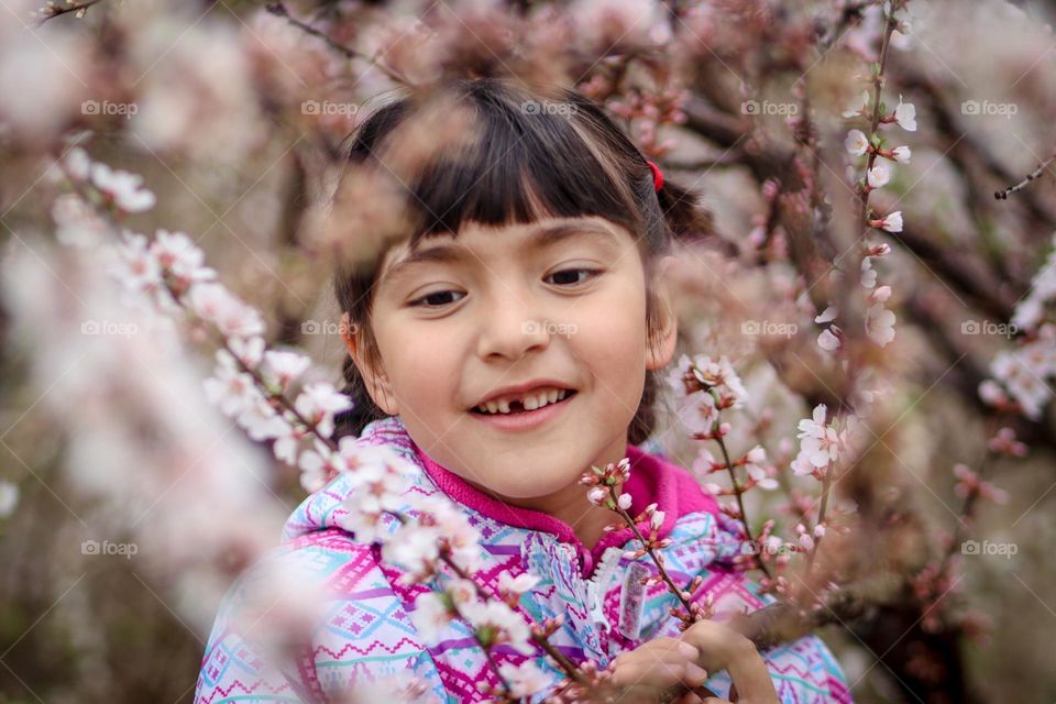 Cute girl among cherry blossom