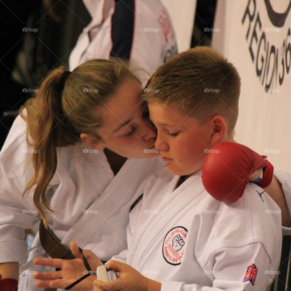 Sibling love and comfort . The picture is different to what it seems. Brother and sister at the karate World Cup. Brother missed sisters performanc