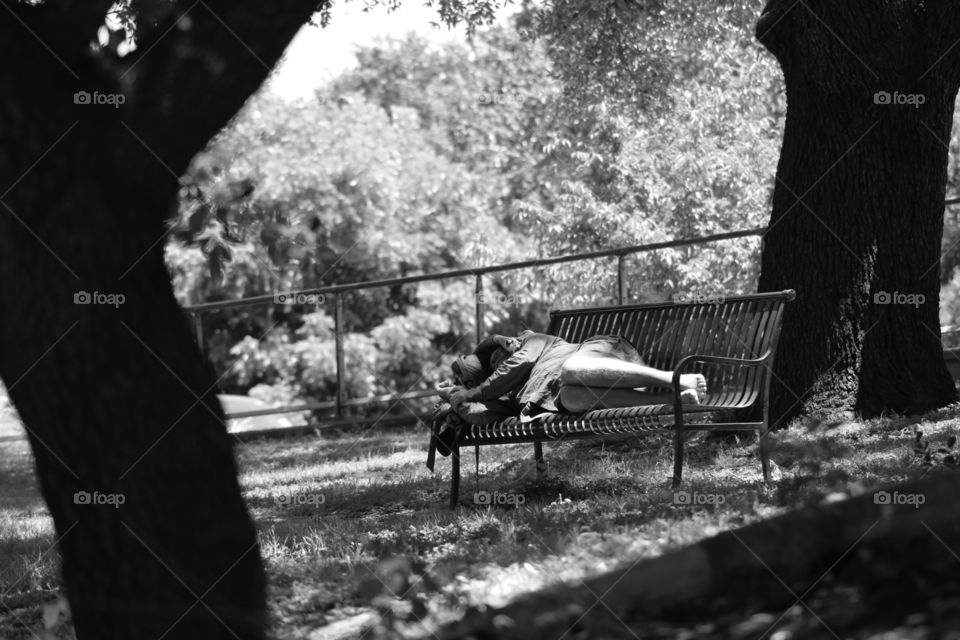 While the conception of Austin is that of a bustling, rich city, there are many homeless people. This is a park bench on Ladybird Lake.