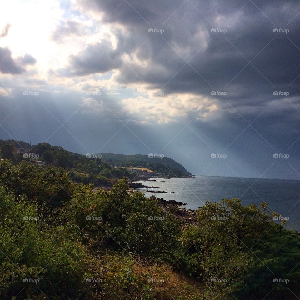 View of sun rays through storm clouds
