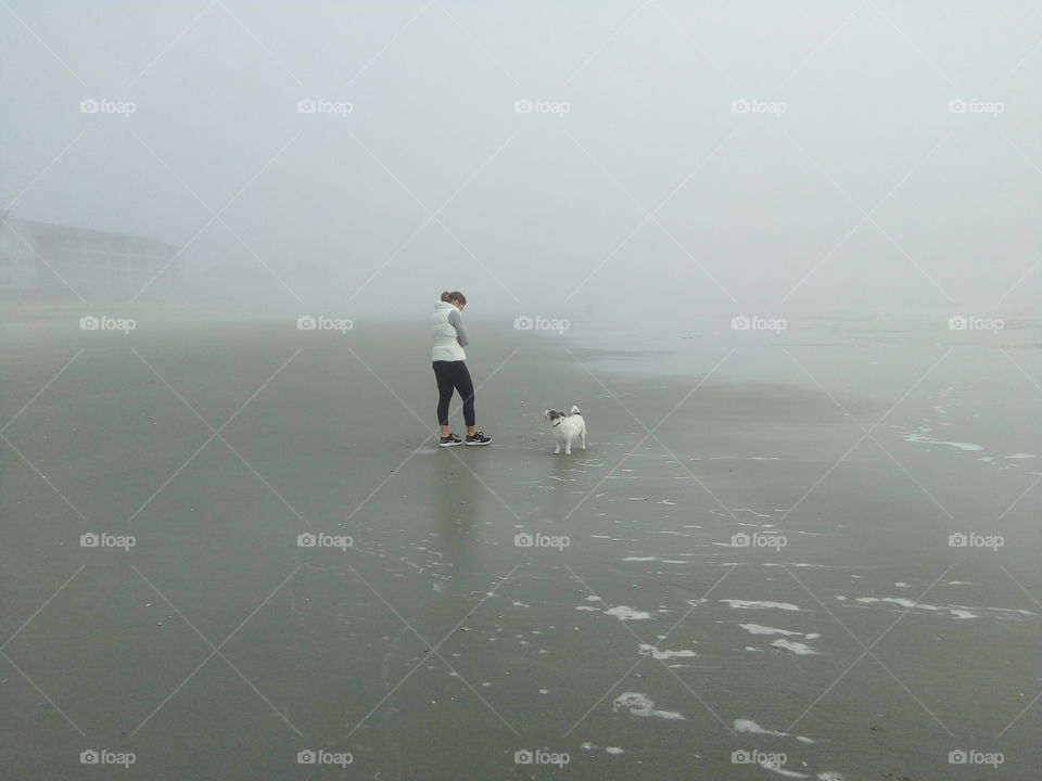 a lady with a dog in the fog