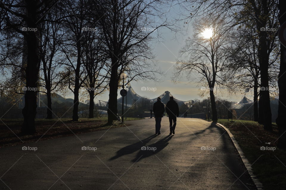 Rear view of two people walking on road