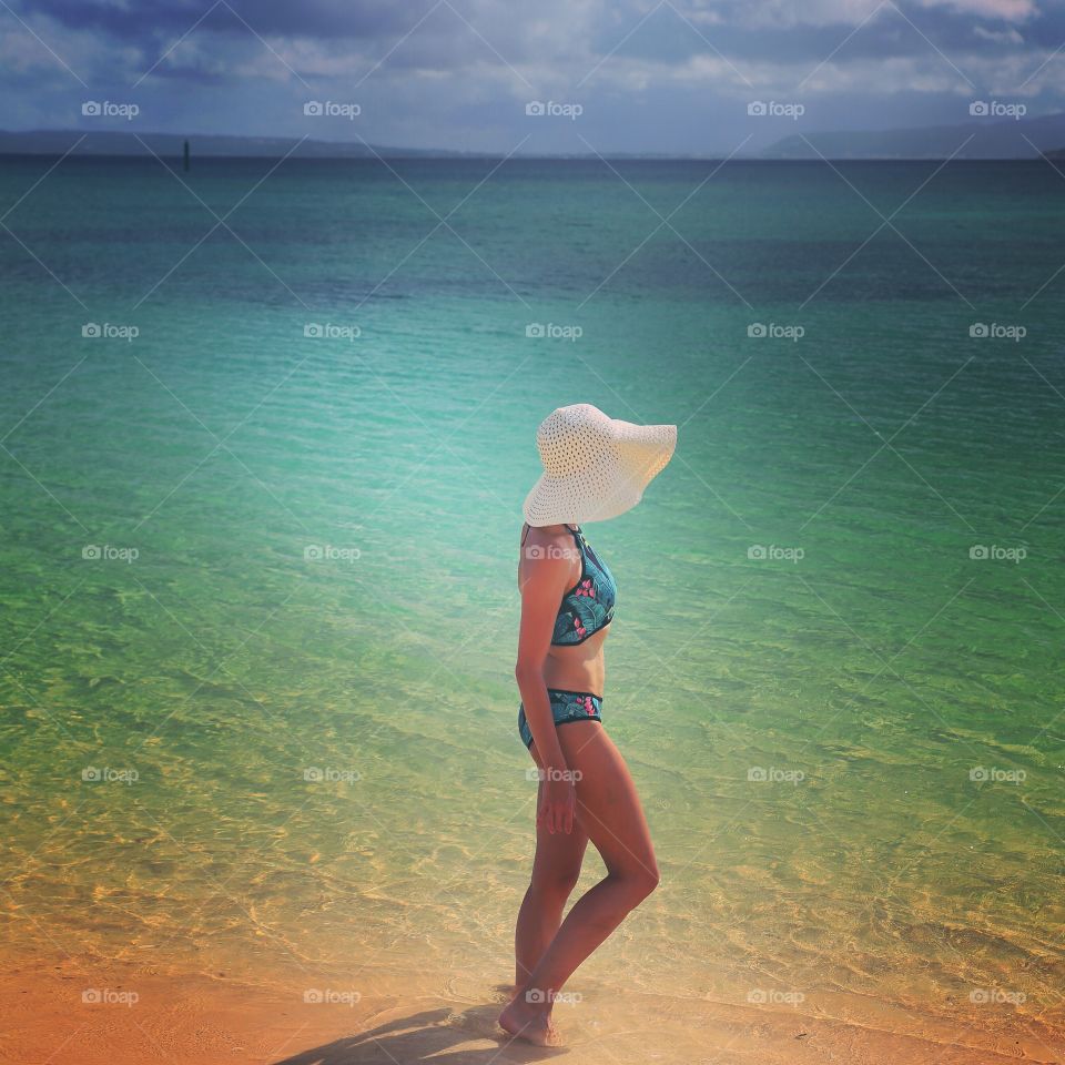 girl in big white hat on a beautiful beach. girl on the beach