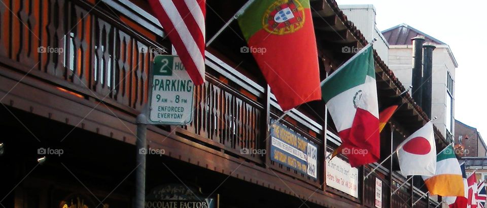 International flags on a railing for a car show