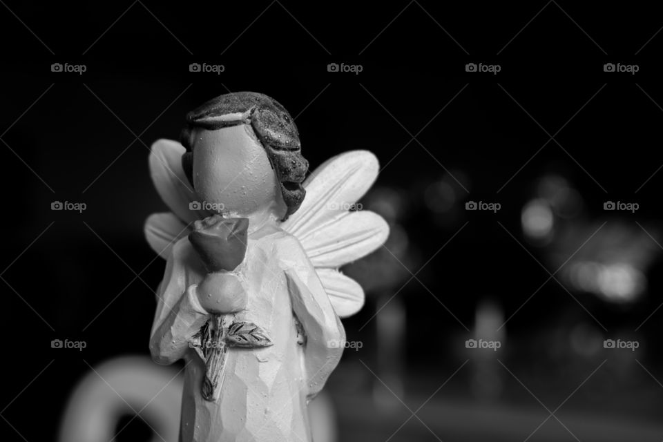 closeup of a statue of a little angel girl holding a rose in black and white perhaps there is a certain someone its ment for