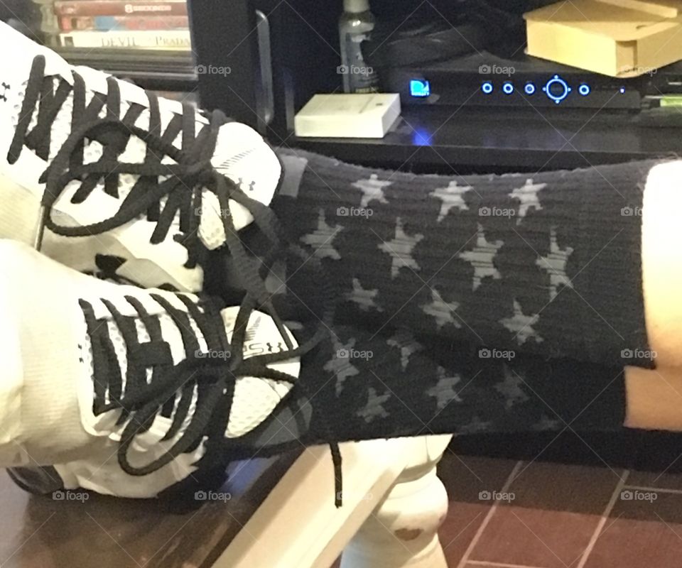 My son's crazy sport socks by Sleefs. Black Stars and Stripes pattern and Under Armour athletic shoes. 