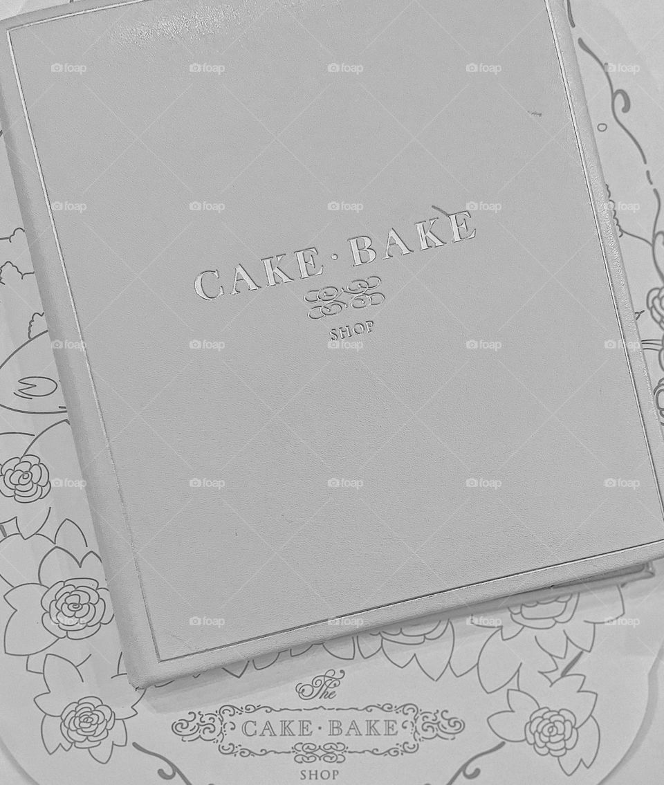 Black and white photo at restaurant, menu at a restaurant, the cake bake shop, looking at the menu, eating at restaurants 