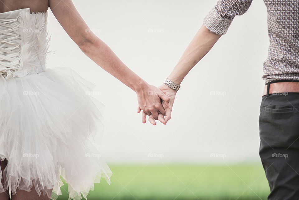 Midsection view of couple holding hands