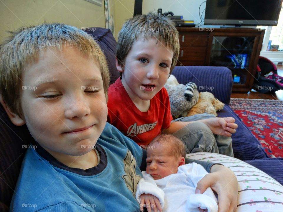 Brothers Holding Their Newborn Sister