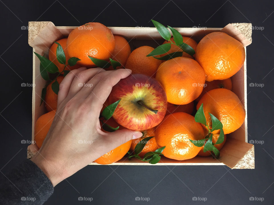 Close-up of person's hand taking a apple