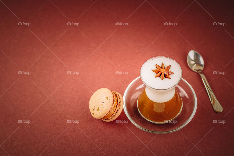 Coffee with milk foam and chocolate macarons with copy space.