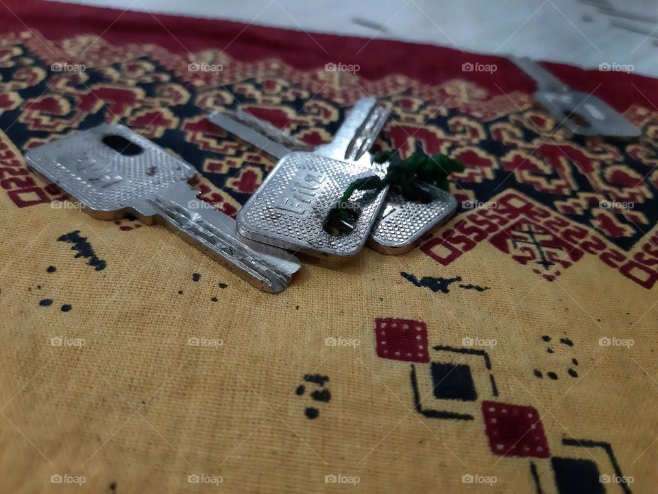 silver keys placed on the colorful table cloth