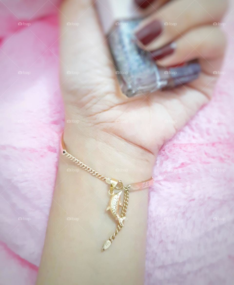 Cute gold bracelet against on pink background