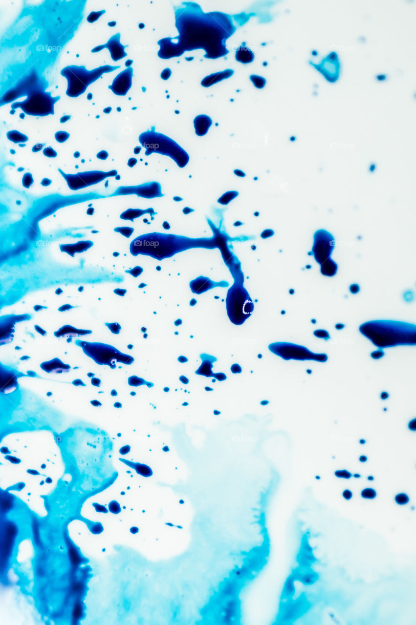 The ink to refill the printer cartridge was spilled onto the white washbasin and the paints blended into abstract drips and patterns.