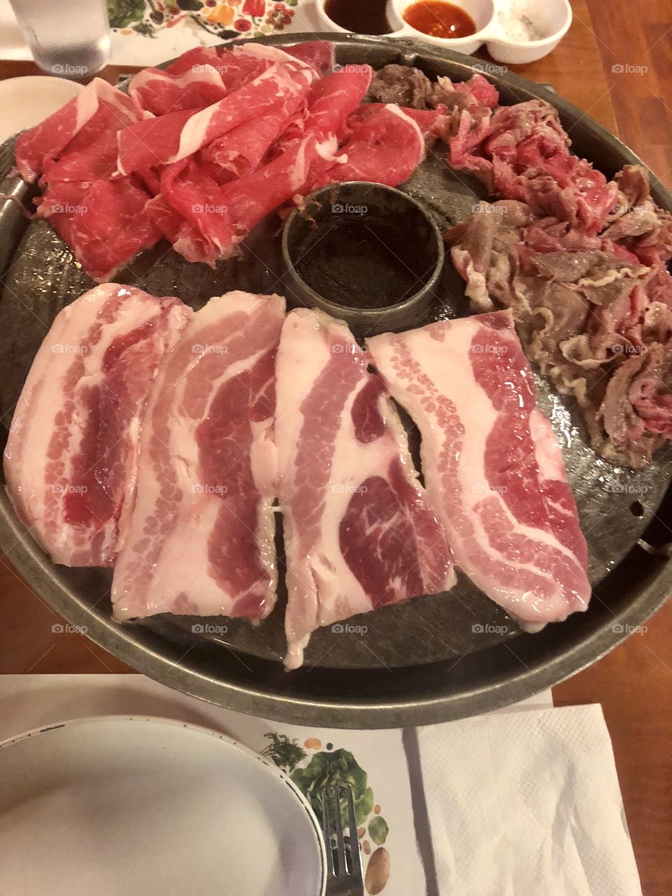 Korean BBQ meats on table grill.