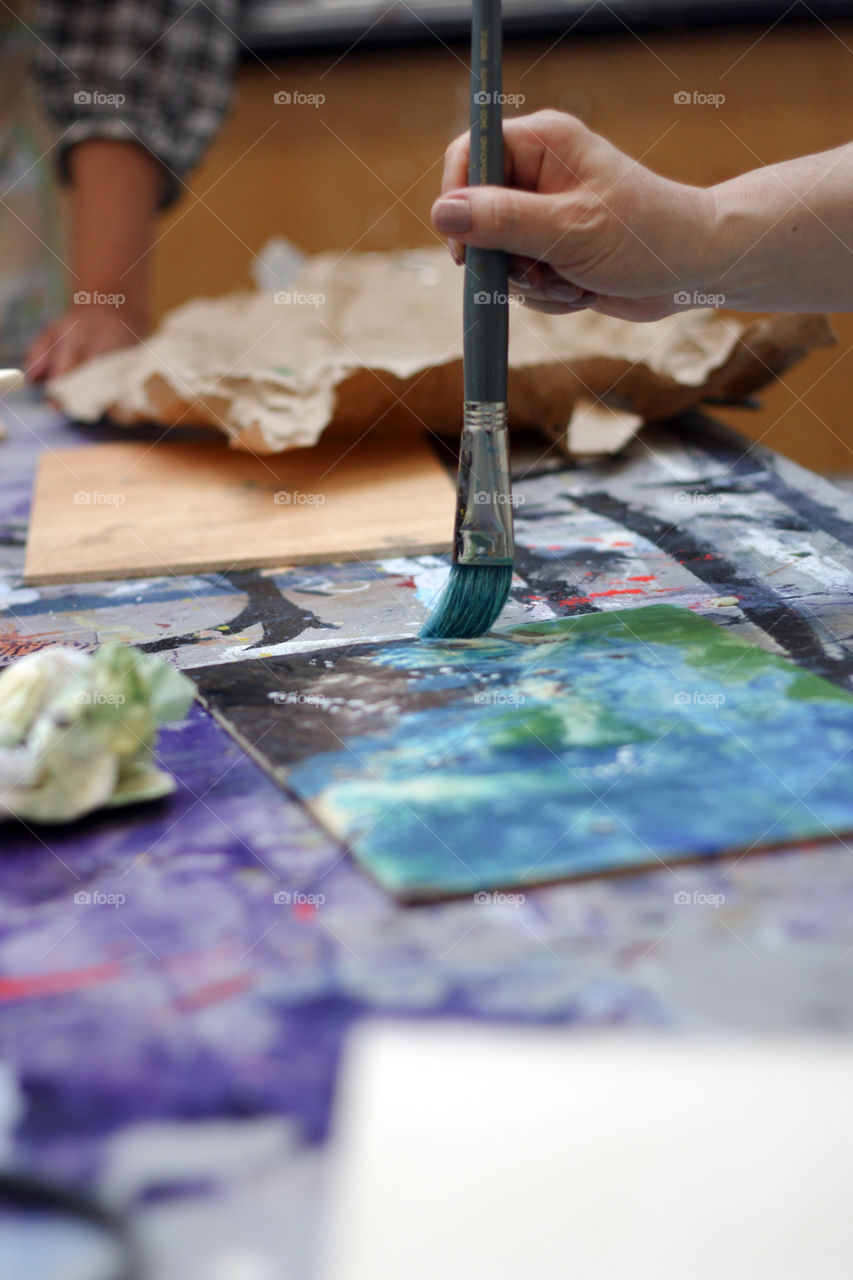 A painter paints encaustic in canvas