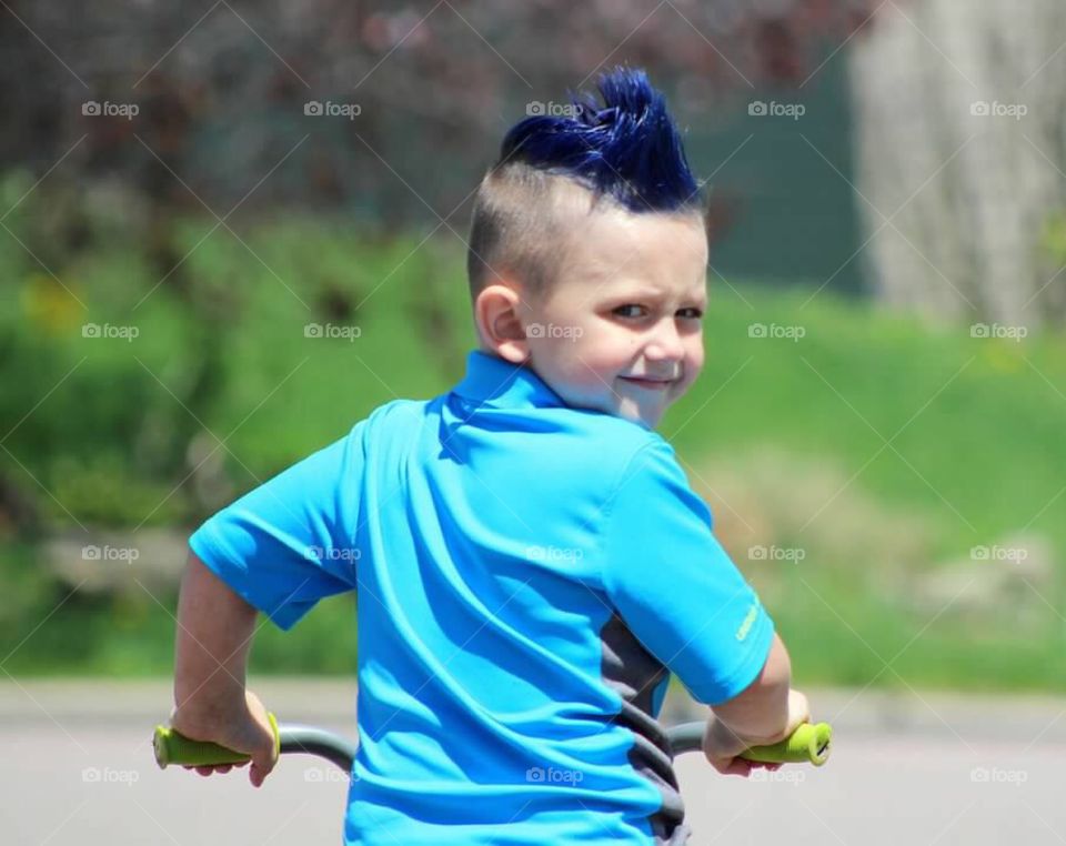 My blue haired little boy sporting a mohawk with attitude written all over his face. 