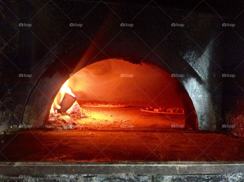 Stove with fire backing pizza