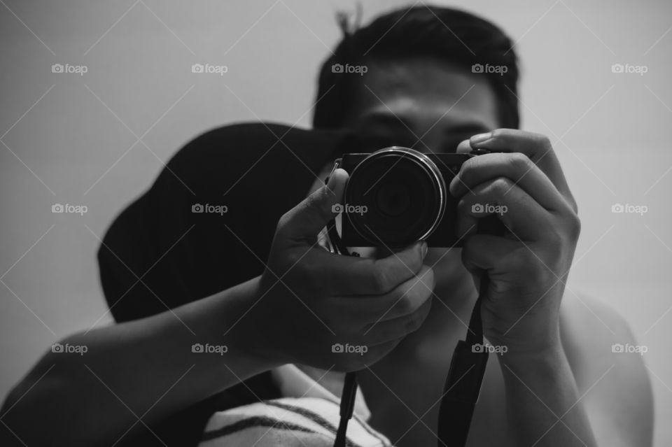 A couple of lovers are hugging in front of a mirror while taking photos