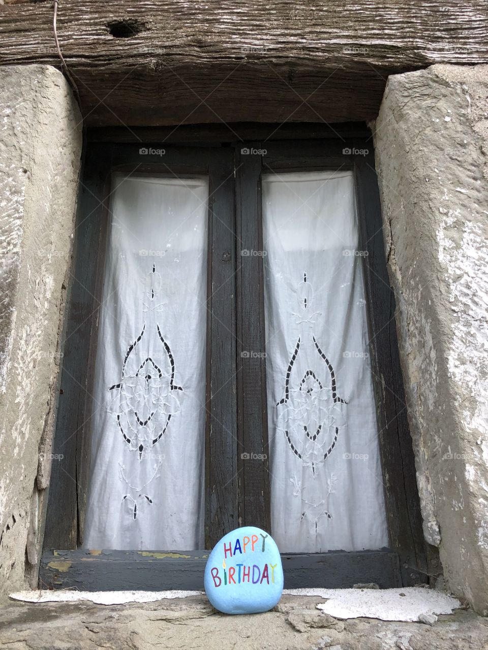 Happy birthday stone front of an old window