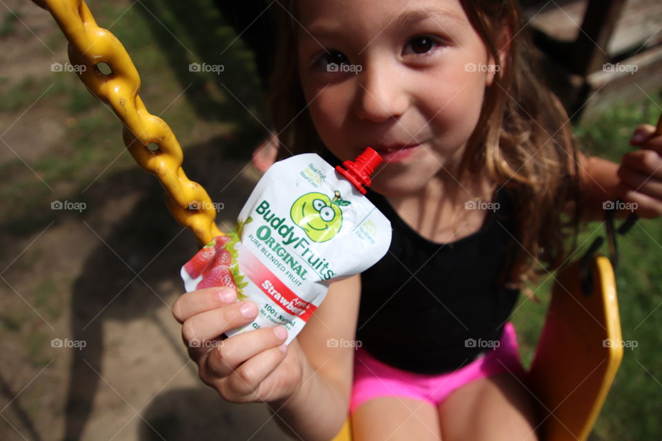 Little girl enjoying buddy fruits outdoors 
