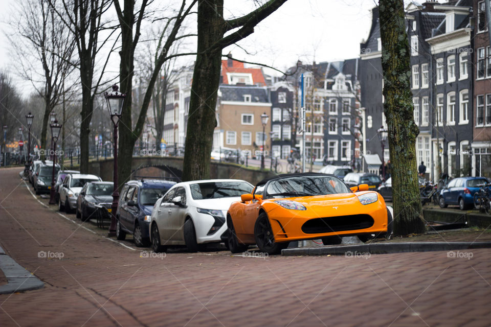 A bright orange car (tesla roadster) in Amsterdam
