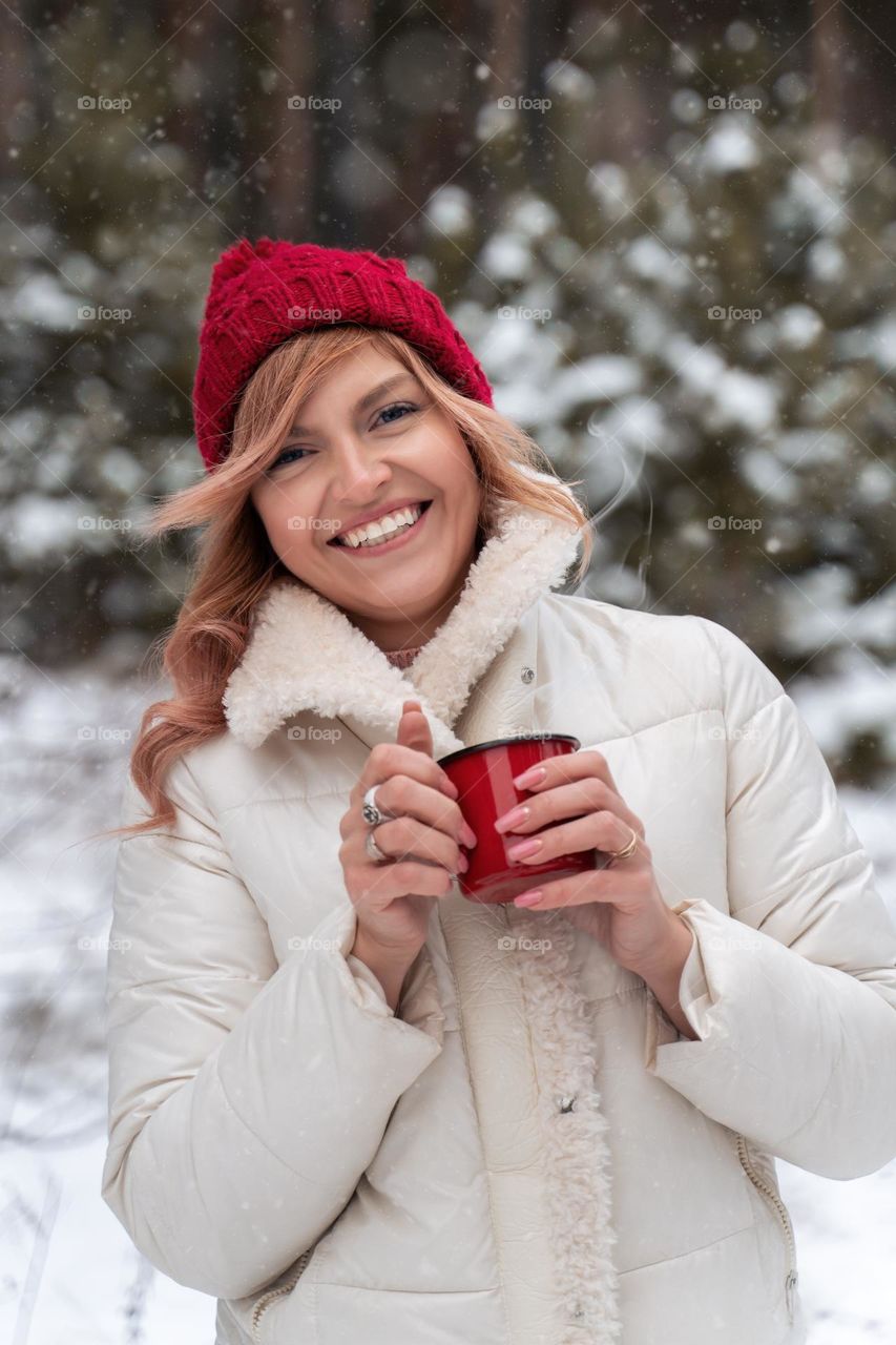 girl in red hat with cup of tea outdoor