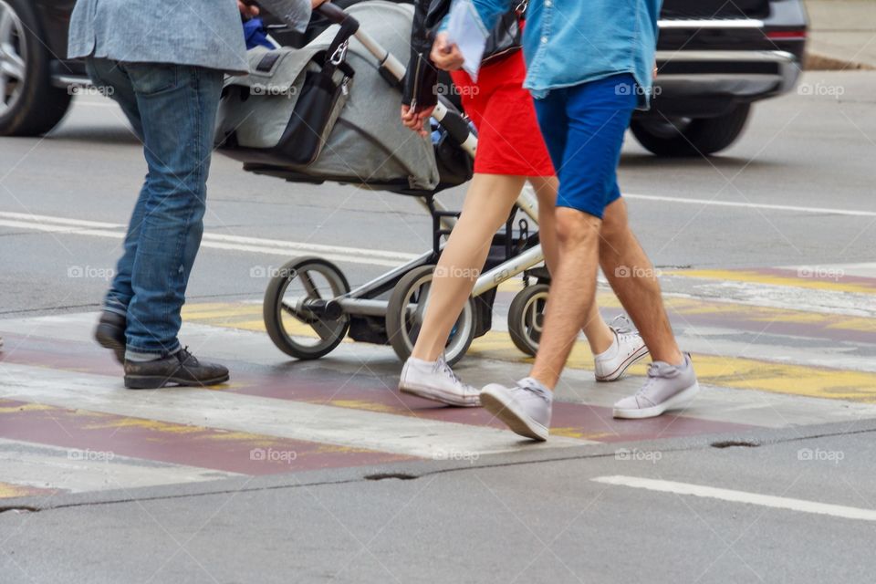 Feet of walking people on a pedestrian walkway