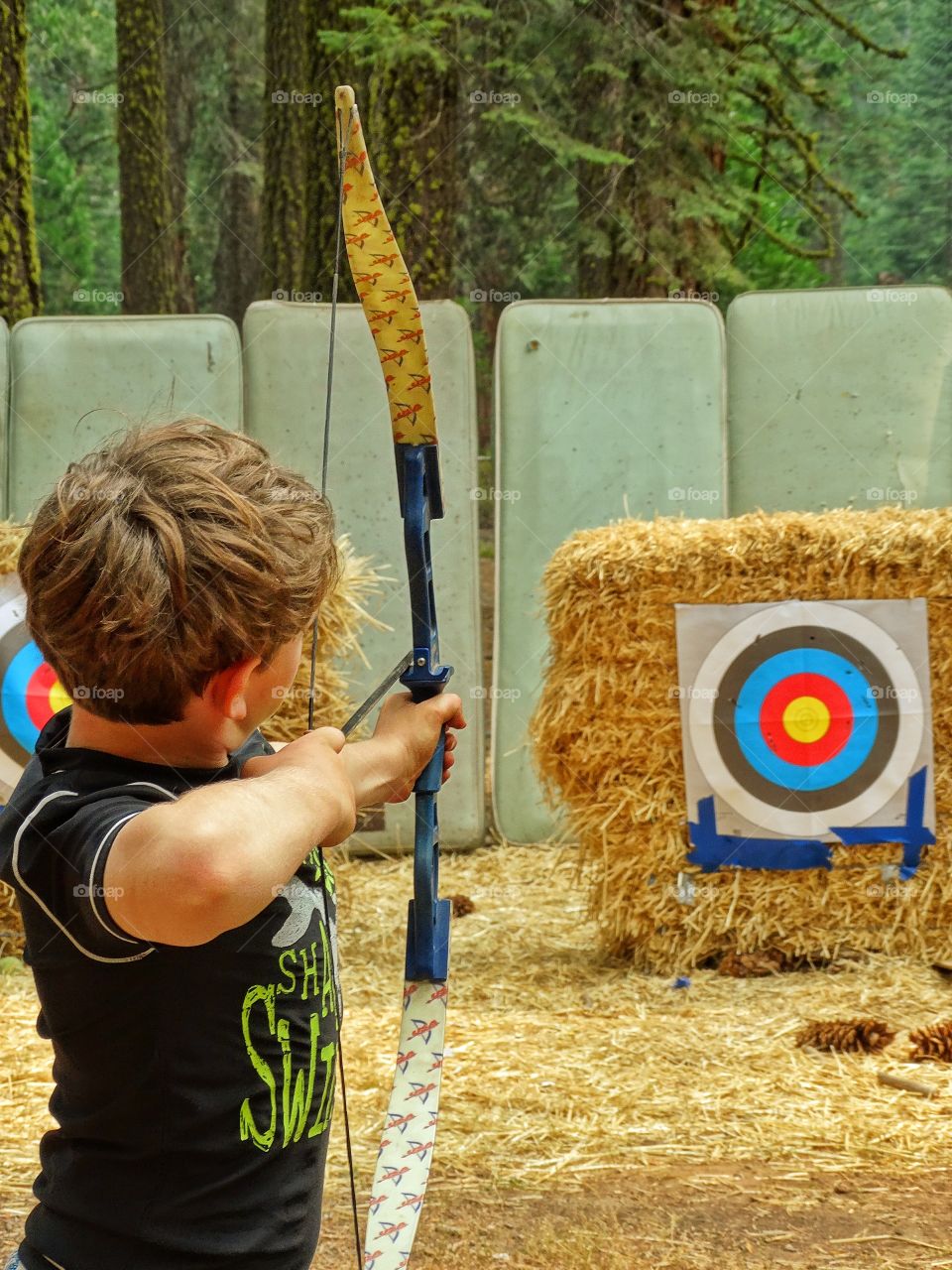 Boy Shooting Arrows. Target Practice At The Archery Range