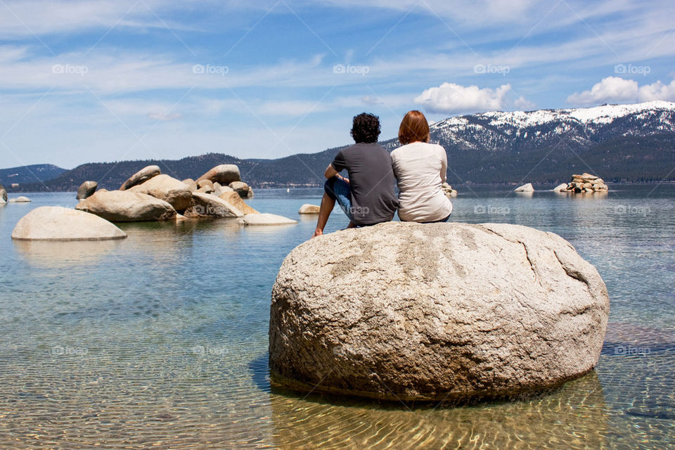 Couple sitting on a boulder