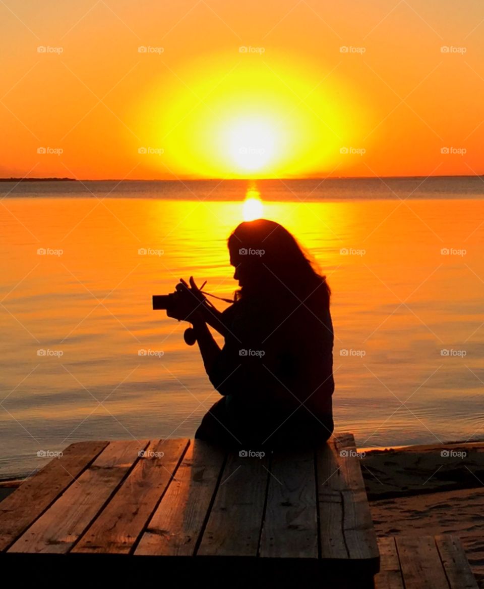 Photographer Sunset! Snapped a photo of a photographer sitting on a picnic table adjusting her camera!