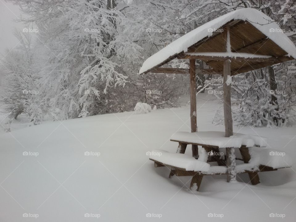 View of picnic table in snow