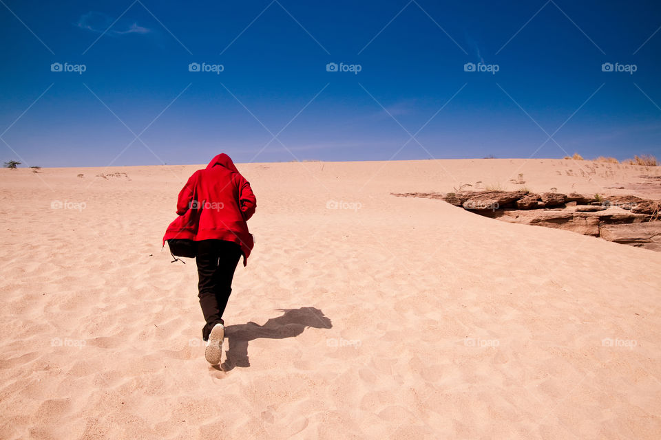 Rear view of a person running on desert