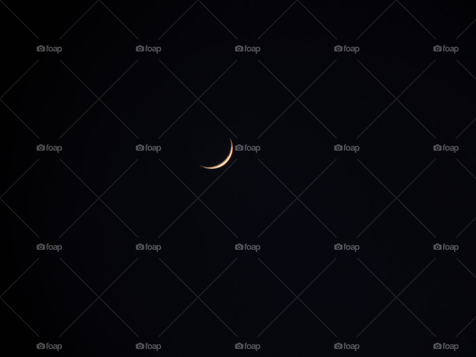 crescent moon captured at night from Nepal, black background, yellow moon, beautiful scenery,