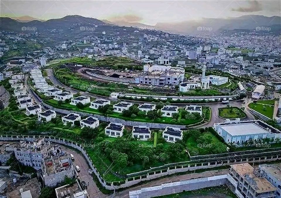 The image embodies a natural natural plate of the mountains of nature, where green agricultural stands are graded on the slopes as if they were lines of a poem, which fog harmoniously wrapped, and clouds hugged them in the mountain knife and the whis