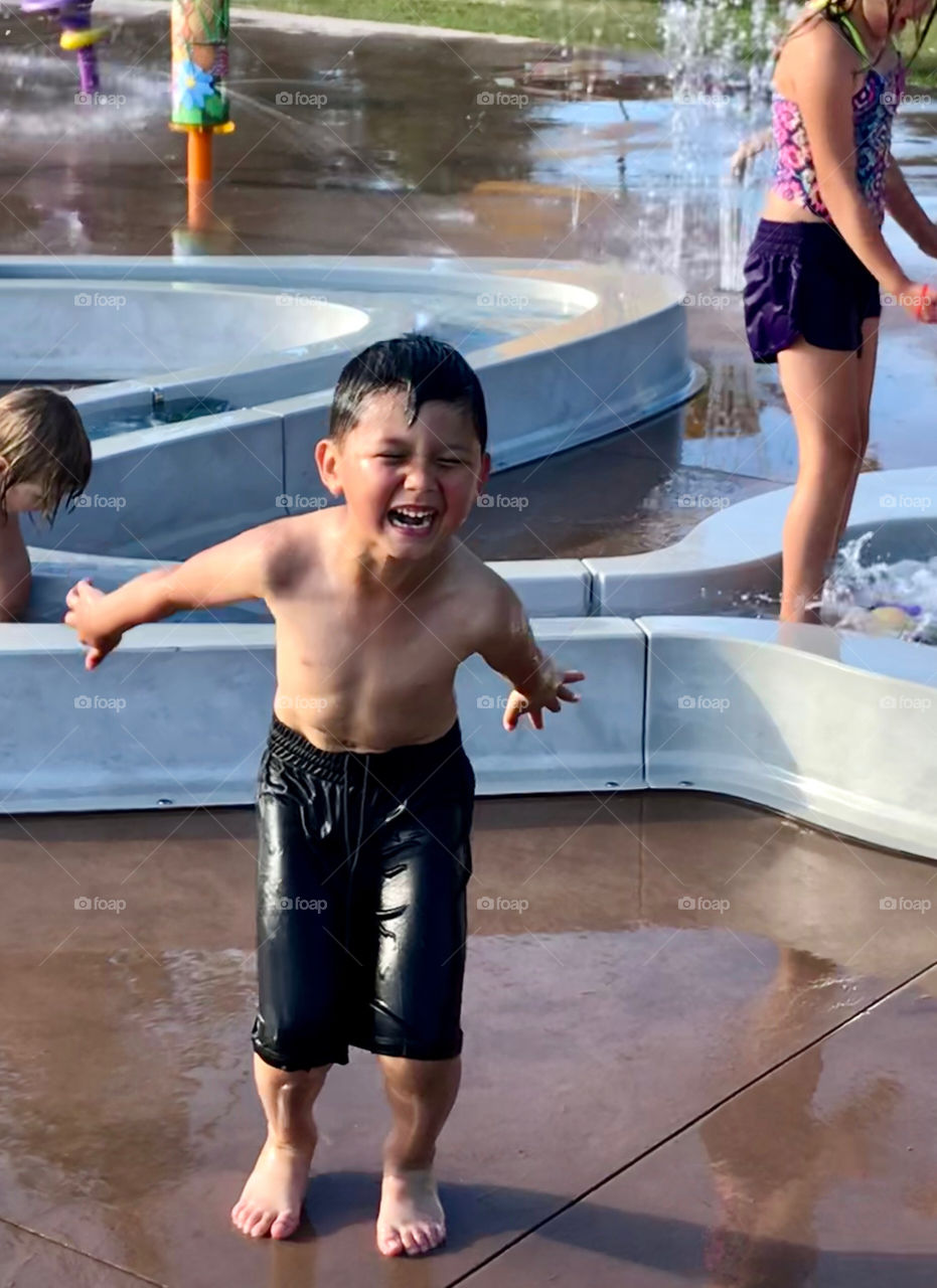 Happy boy jumping in a water park