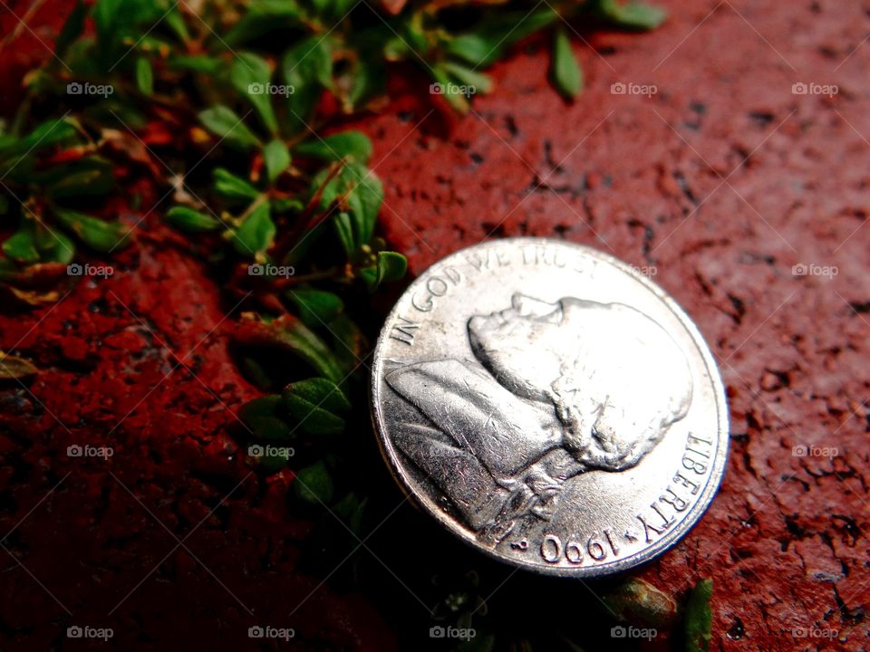 found change- in God we trust. Shiny United States nickle found on a path walkway. In God we trust... liberty 1990.
