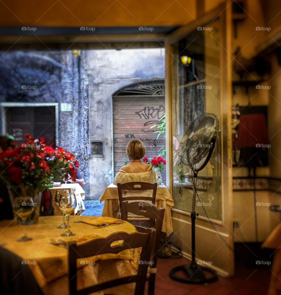 Woman sitting alone in a restaurant in Rome