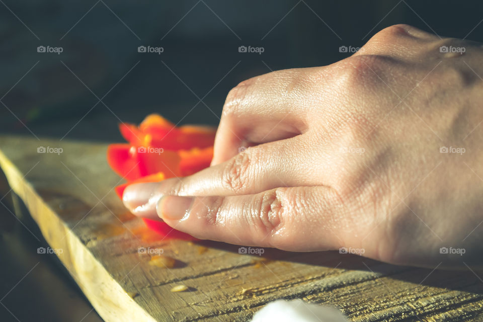 Closeup of hand cutting paprika for cooking