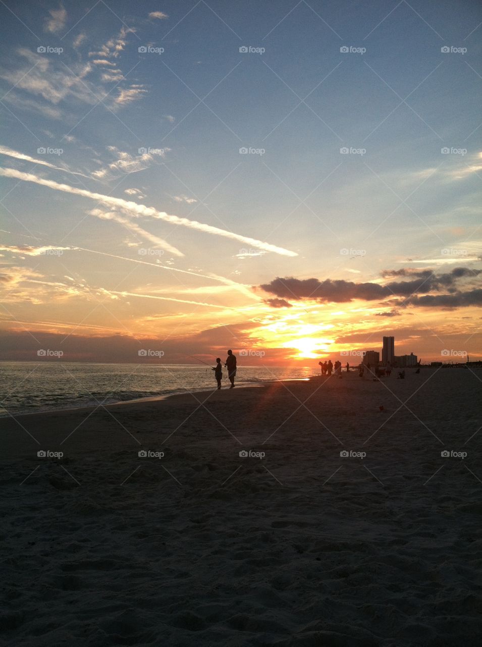 Walking Silhouettes in the beach during sunset.