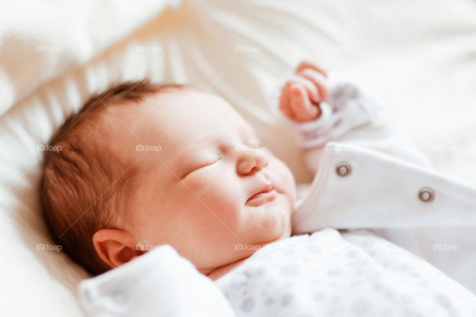 Newborn baby sleeping on bed