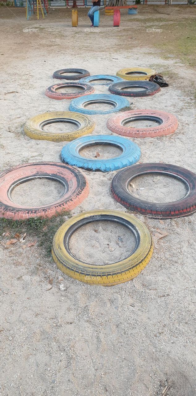 Playground, colored rubbers in the sand, circles, games for children.