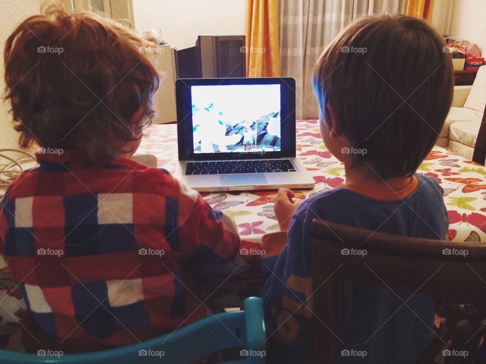 Two kids staring at computer monitor