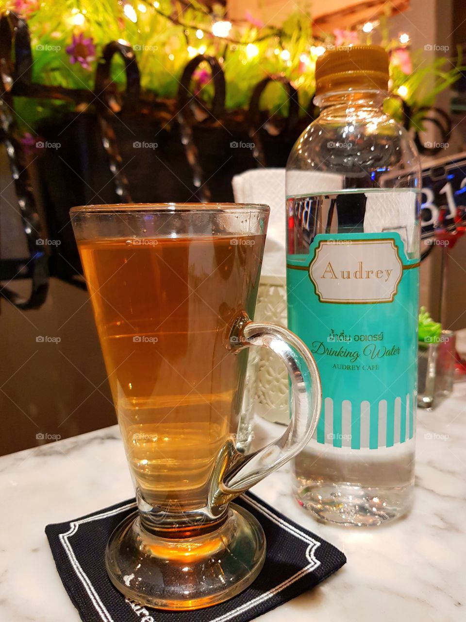 A glass of lemon grass juice with a bottle of water