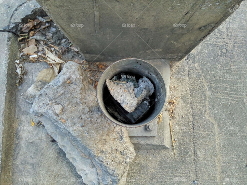 rock in the hole of steel pipe beside concrete column