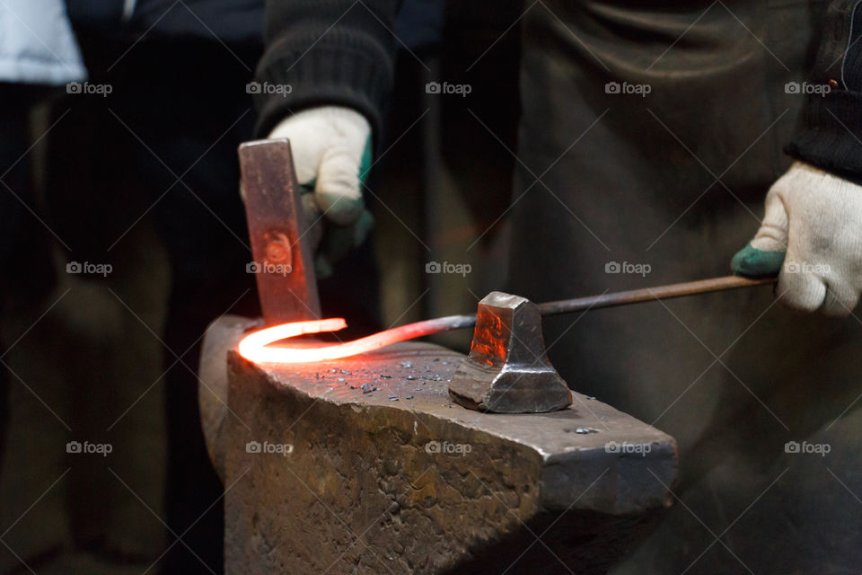 Blacksmith forges a horseshoe