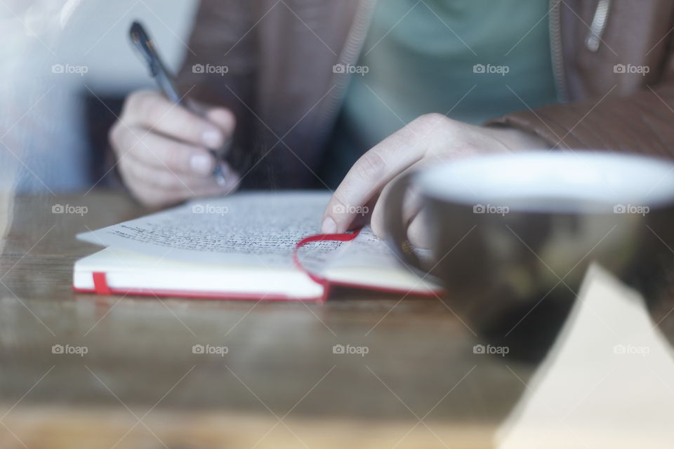 Man writing and drinking coffee. 