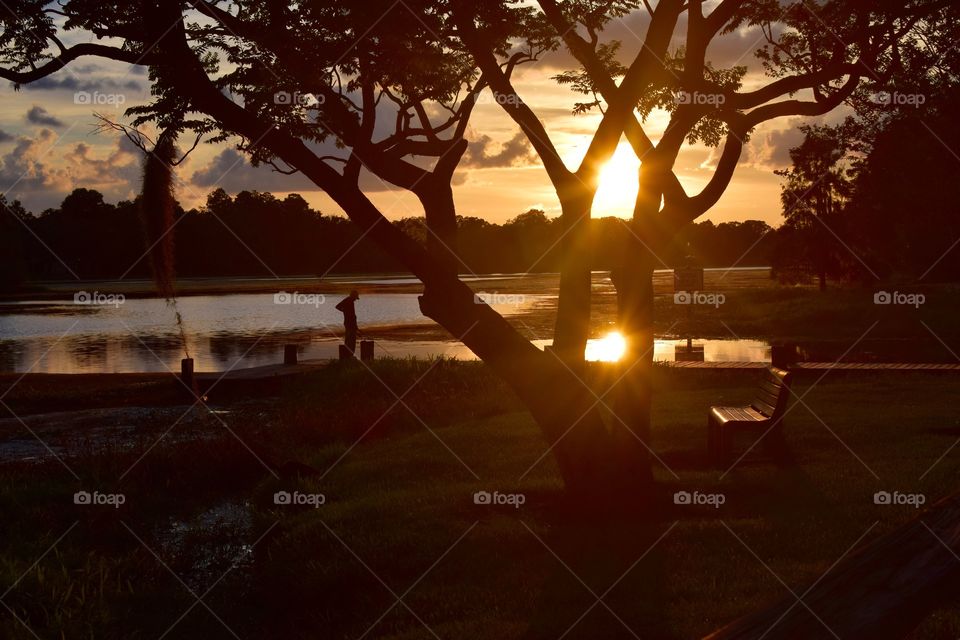 After a relaxing day of fishing on a lake in a rural community in Florida this older gentleman enjoys a beautiful sunset.